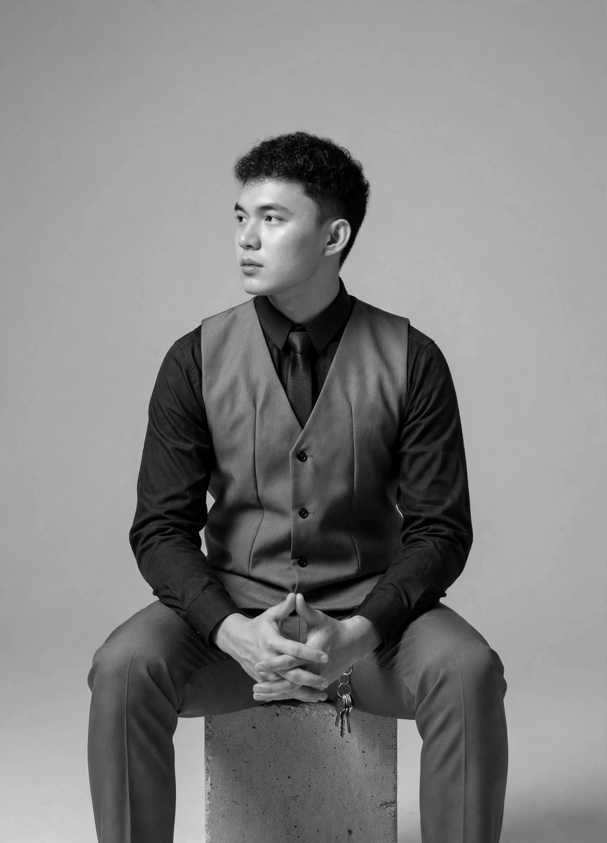 Lorenz Malabanan, seated, in a black-and-white studio portrait